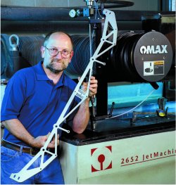 Sam Charnegie, Operations Manager at LMS Stamping, with a part cut on the OMAX JetMachining Center
